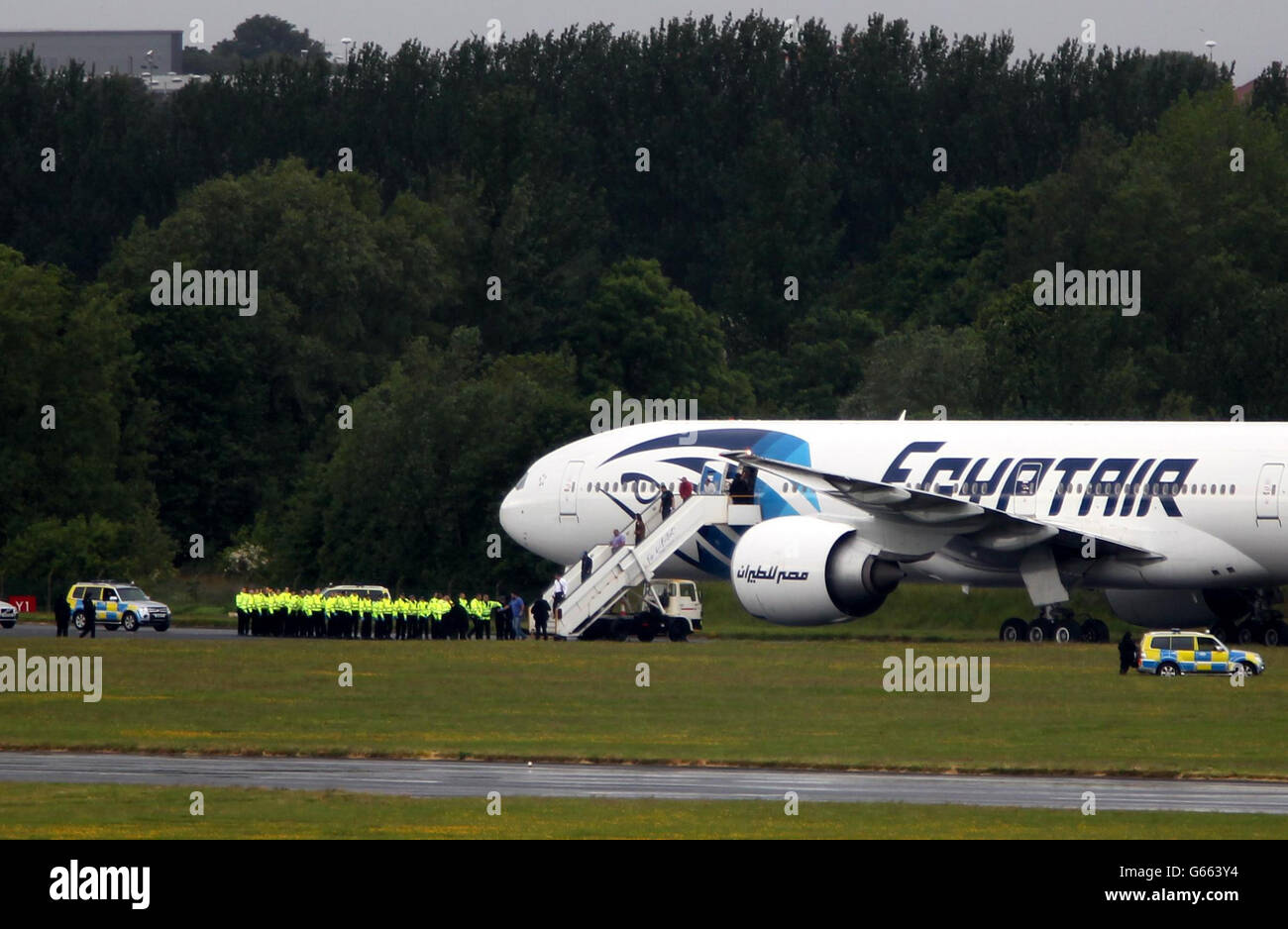 La polizia circonda l'aereo Egyptair che vola dal Cairo a New York dopo che è stato deviato all'aeroporto di Prestwick, Ayrshire, dopo che una nota sospetta è stata scoperta sull'aereo. PREMERE ASSOCIAZIONE foto. Data immagine: Sabato 15 giugno 2013. L'aereo è stato scortato all'aeroporto di Prestwick da Typhoon da RAF Leuchars durante il suo volo dal Cairo all'aeroporto JFK a New York. Un portavoce dell'aeroporto di Prestwick ha detto che è atterrato intorno alle 14.30 ma l'aeroporto continua a funzionare normalmente, con i voli che continuano da quando l'aereo egittair è atterrato. Nada Tafik, dipendente della BBC, è a bordo dell'aereo e. Foto Stock