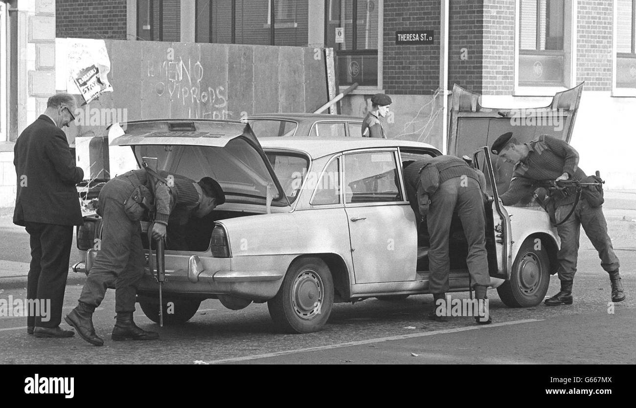 Le truppe armate cercano a fondo un'auto arrestata in uno dei blocchi stradali nella zona di Falls Road di Belfast. Foto Stock