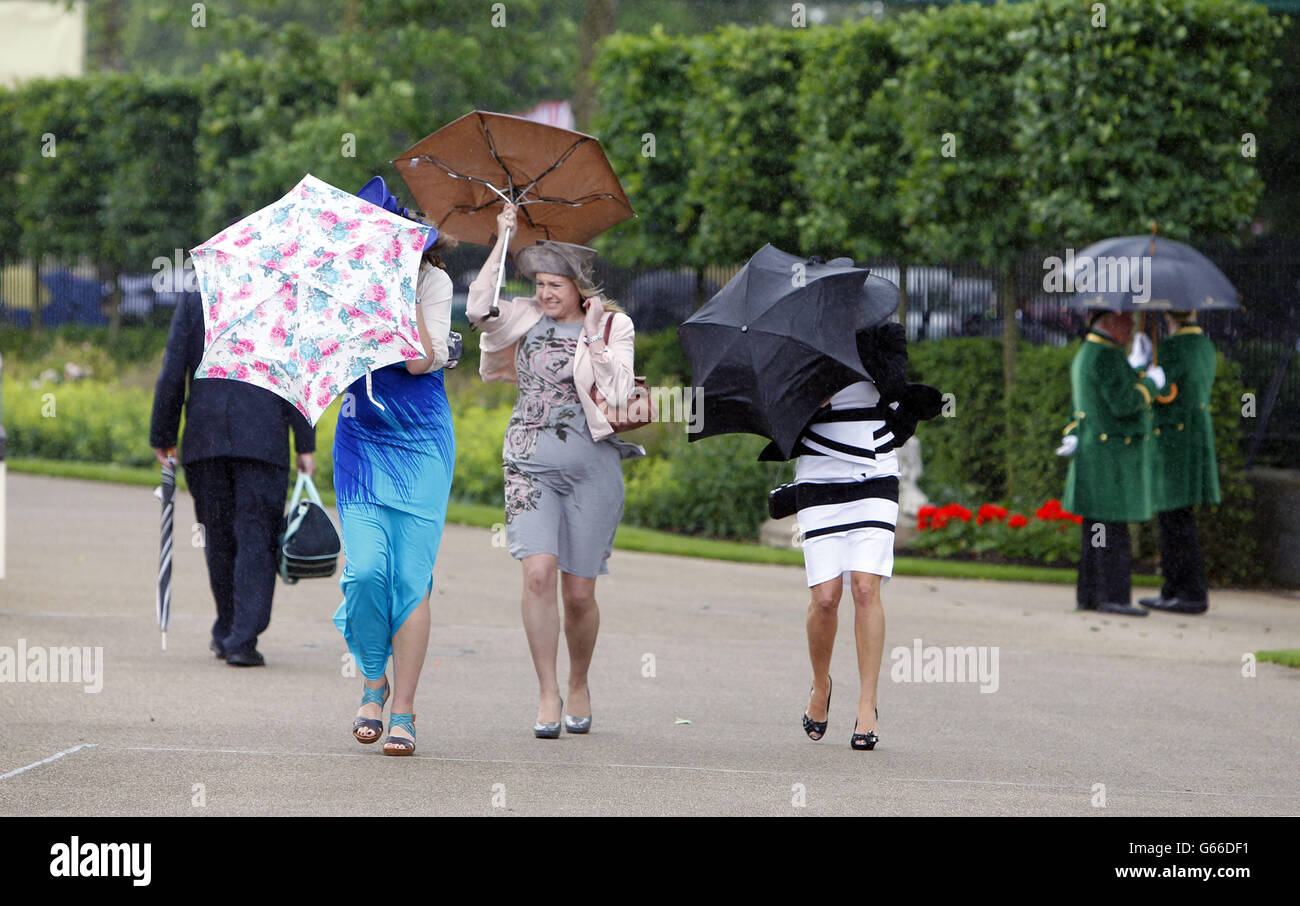 Gli amanti della corsa lottano in condizioni ventose durante il quinto giorno del Royal Ascot Racecourse di Ascot, Berkshire. Foto Stock