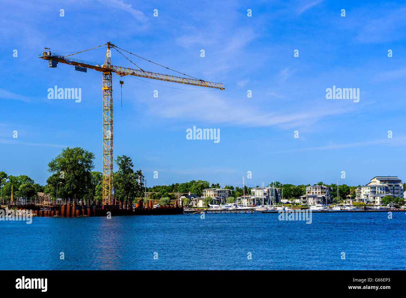 Vastervik, Svezia - 19 Giugno 2016: vista su un mare sito in costruzione e i vicini edifici di appartamenti. Una gru freni Foto Stock