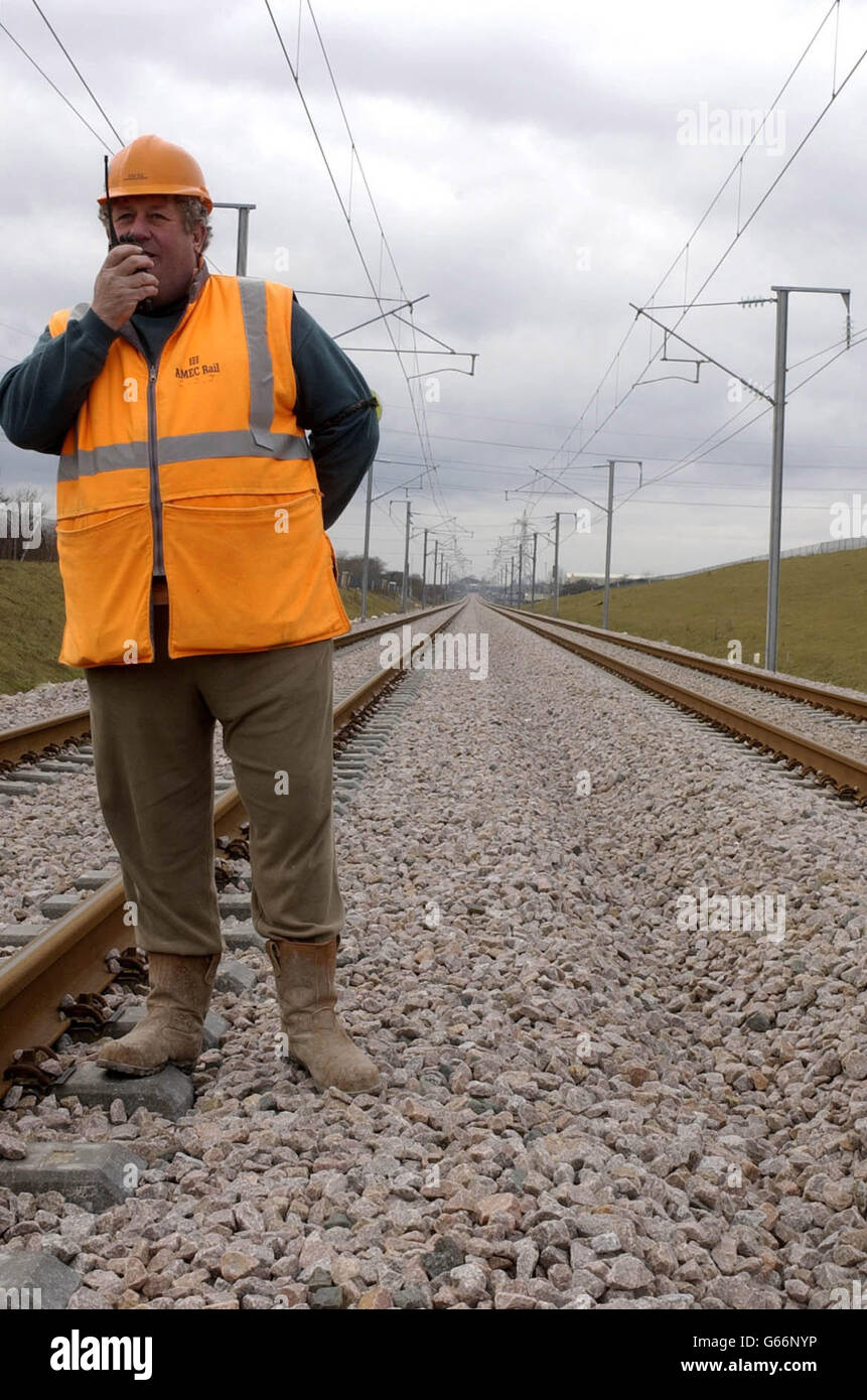 L'addetto alla sicurezza Cliff Jamieson cammina lungo il nuovo collegamento ferroviario del tunnel della Manica vicino al Viadotto Grange Alders nel Kent, mentre i tecnici effettuano i controlli finali sulle linee elettriche aeree a 25,000 volt sulle 46 miglia (74 km) della nuova ferrovia. *... tra Fawkham Junction, vicino Swanley, e il complesso del Tunnel della Manica a Cheriton. Una volta completato nel 2007, i 5.2 miliardi di CTRL dimezzeranno i tempi di viaggio dal centro di Londra al tunnel sotto la Manica. Presto i treni Eurostar inizieranno a testare la linea a velocità fino a 186 mph. Foto Stock