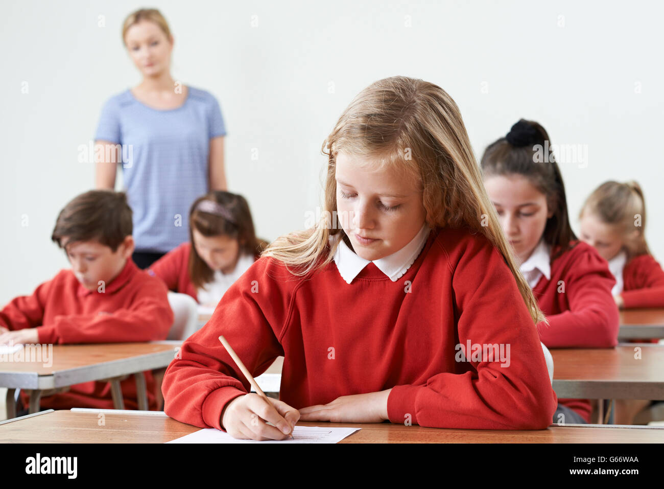 Pupilla d femmina a scrivania prendendo esame scolastico Foto Stock