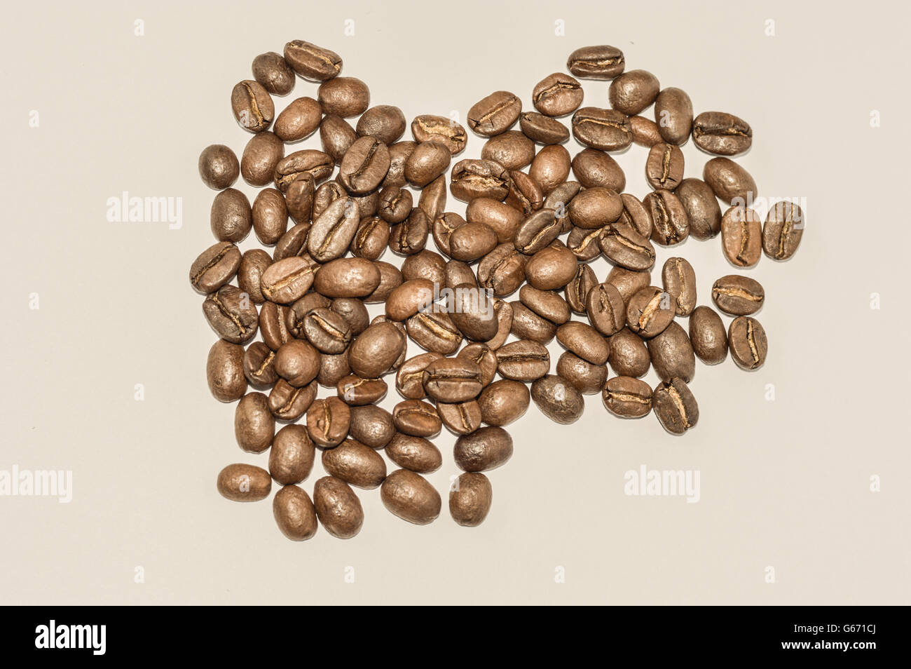 I chicchi di caffè isolato su bianco/sfondo beige Foto Stock