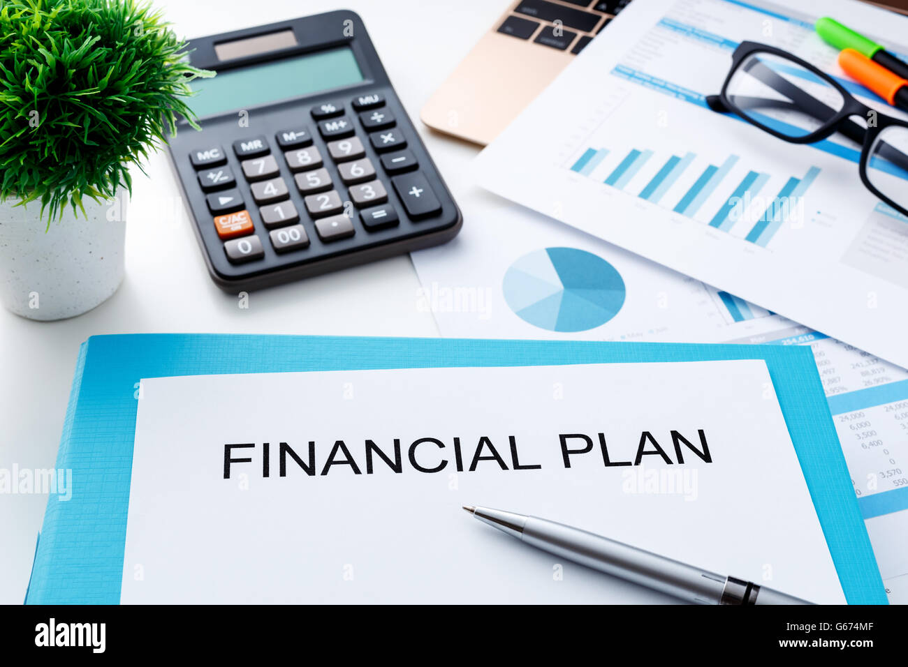 Piano finanziario con la calcolatrice e grafico finanziario su laptop Foto Stock