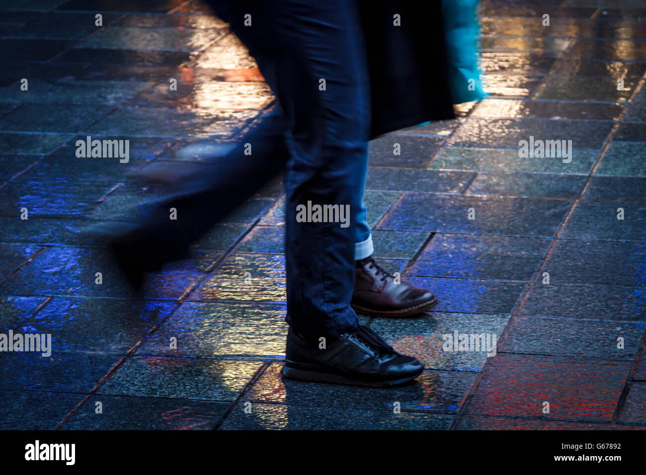 Camminare insieme in neon sotto la pioggia Foto Stock
