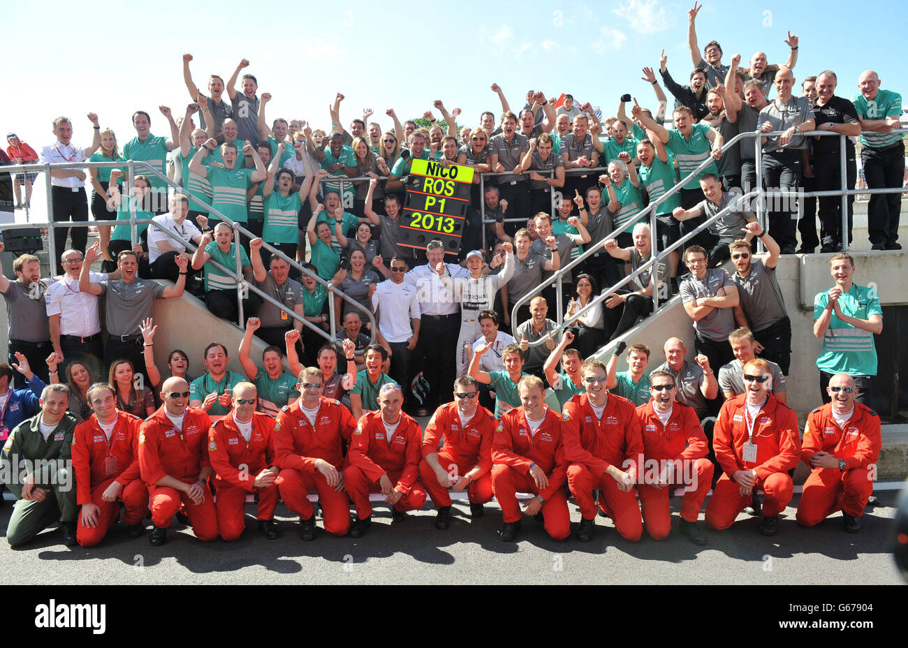 Mercedes' Nico Rosberg festeggia la vittoria del Gran Premio di Gran Bretagna Santander 2013 con il compagno di squadra Lewis Hamilton, il team principal della Mercedes F1 Ross Brawn e i membri della Red Arrows al circuito di Silverstone, Towcester. Foto Stock