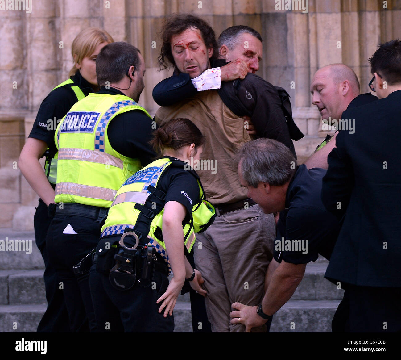 Un uomo è cercato fuori York Minster dalla polizia e David Smith (collo di presa) Un membro del personale degli Arcivescovi dello Yorks dopo che l'uomo è stato trattenuto nei cantieri dell'arcivescovo di Canterbury, il Rev.mo Justin Welby e dell'arcivescovo di York, il Dr. John Sentamu, mentre si sono trattati per l'inizio del servizio di Santa comunione. Foto Stock