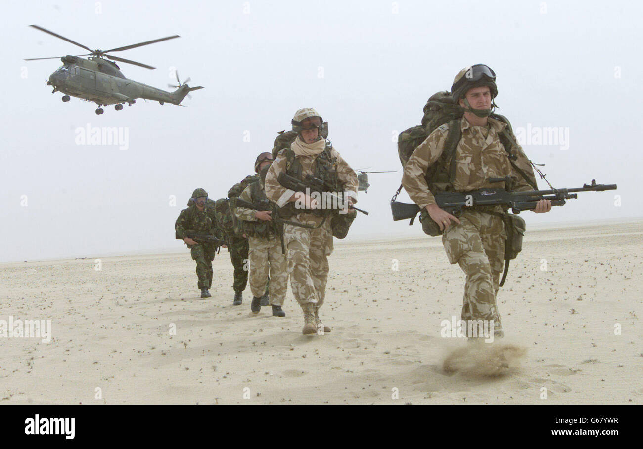Soldati britannici del 51 ° reggimento dell'aeronautica reale Sqn pattuglia nel deserto del Kuwait, mentre un elicottero Puma decollo durante un'operazione di attacco aereo pratica progettato per catturare l'aeroporto nemico, fuori Kuwait City. Foto Stock