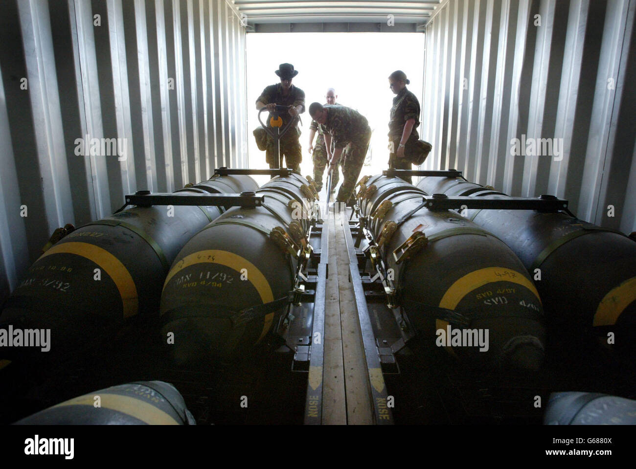 I tecnici della British Royal Air Force Weapons scaricano bombe da 1000 lb dai contenitori mentre li preparano per l'uso nella loro base in Kuwait. Sia gli US che i Royal Air Force Harriers stanno continuando a pattugliare la zona no fly nel sud dell'Iraq. Foto Stock