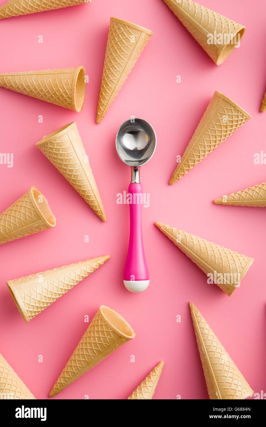 Cono di wafer e gelato scoop su sfondo rosa Foto Stock