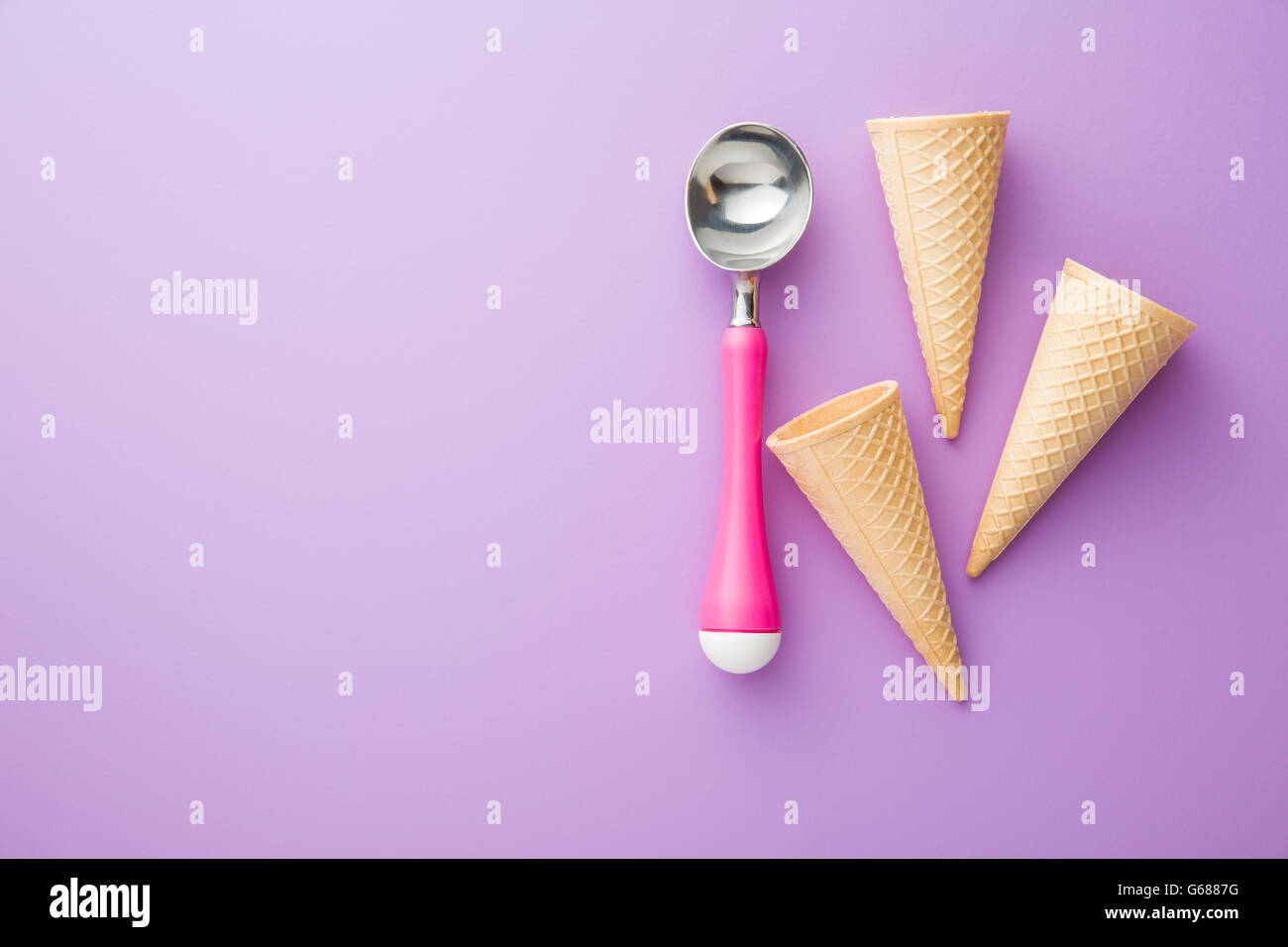 Cono di wafer e gelato scoop su sfondo viola. Vista dall'alto. Foto Stock