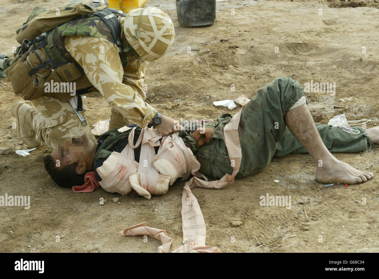 Medici dal 40 Commando, i Marines reali trattano un iracheno ferito dopo aver preso la penisola di Alfaw. Foto Stock