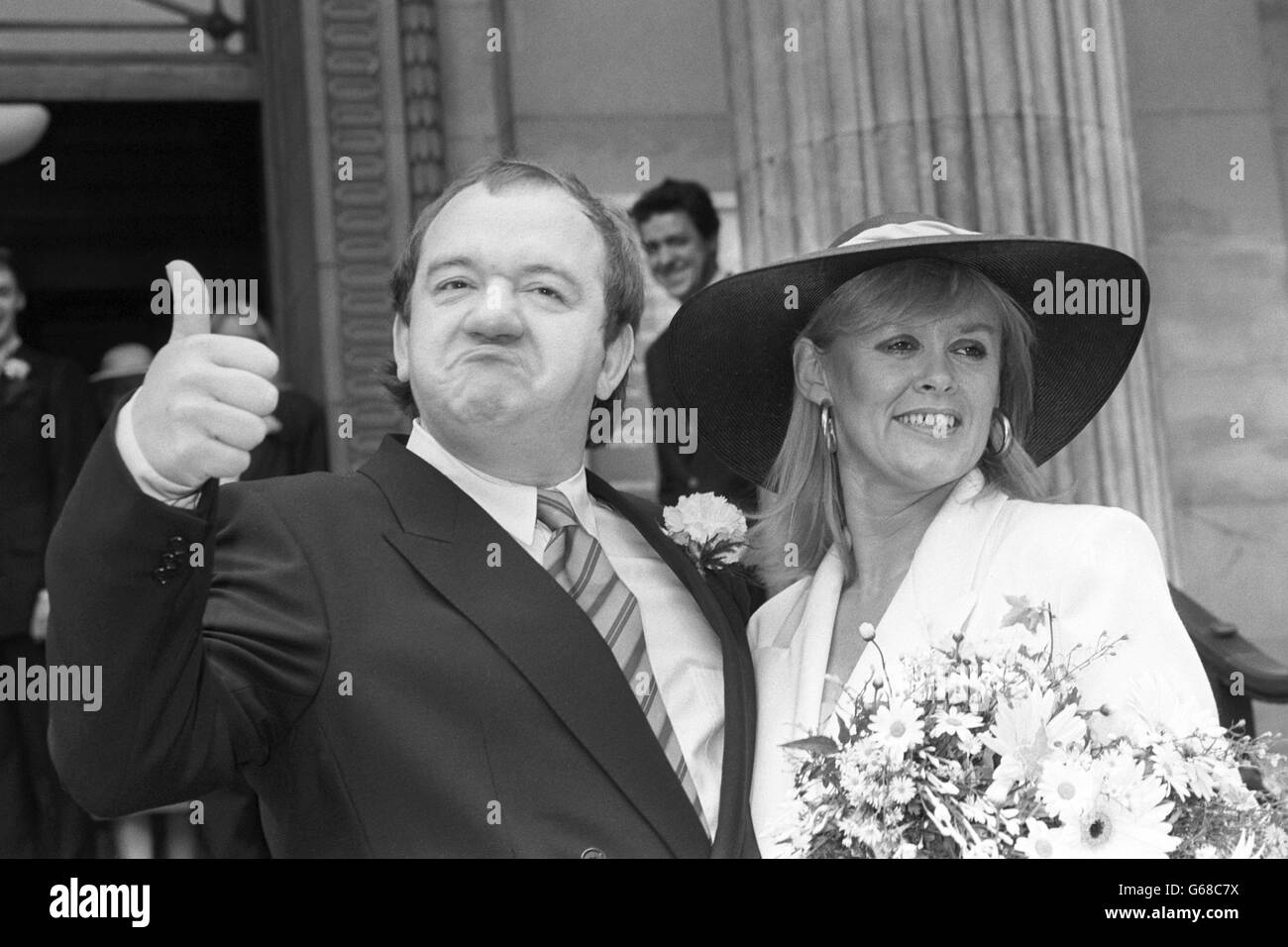Il comico Mel Smith con la sposa Pamela Gay-Rees fuori dall'ufficio del registro di Westminster a Londra. Il comico partner di Smith, Griff Rhys Jones, può essere visto sullo sfondo. Foto Stock