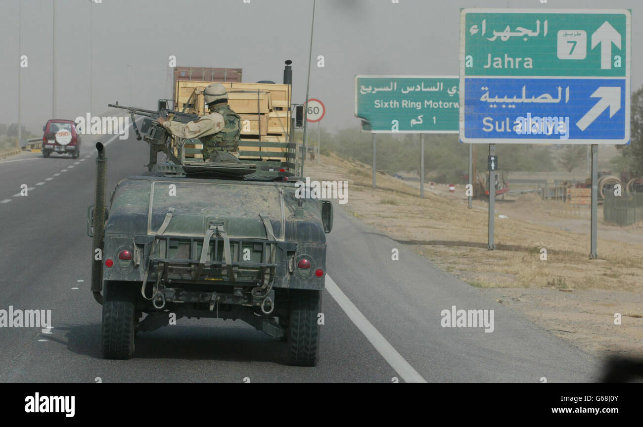 Soldati americani Guardia convoglio in Kuwait. Un esercito americano Humvee custodisce un convoglio mentre viaggia verso nord fuori da Kuwait City, Kuwait. Foto Stock
