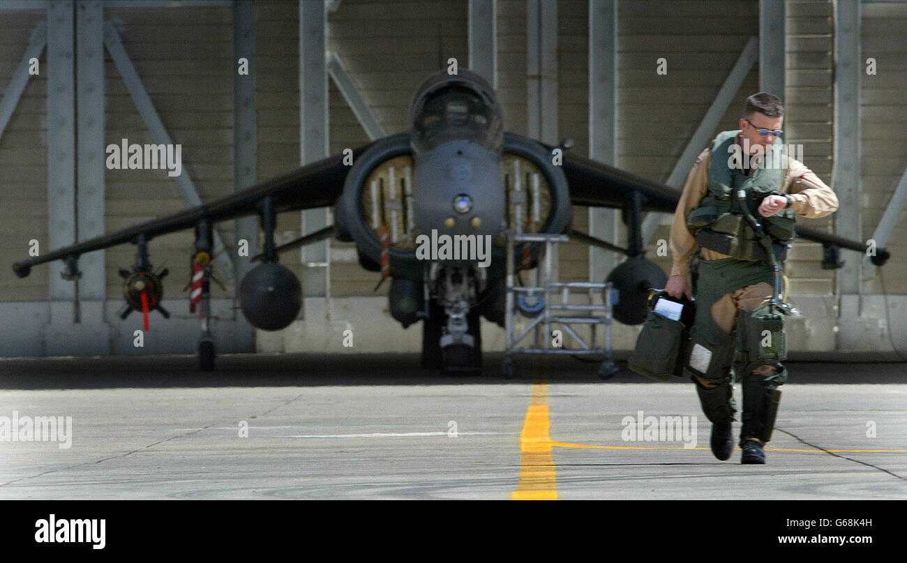 Il pilota britannico Harrier, il leader Squadron Andy Lewis, controlla il suo orologio mentre cammina verso il suo Harrier armato GR7, sotto un riparo in Kuwait. Gli aerei degli Stati Uniti e della Gran Bretagna continuano a far rispettare la zona di non volo sopra l'Iraq meridionale. Foto Stock