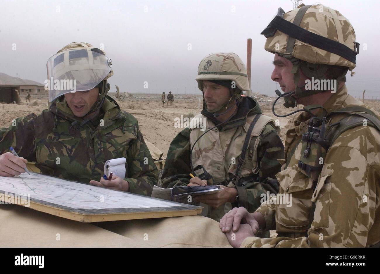 (l/r) Flight Leautenant Chris Long, di 5131 Squadron Bomb Disposal, con sede a RAF Wittering, slip la sua controparte americana così come Wing Commander Mark driver, OC 4 TAC sto (Tactical Survive-to-Operate) Squadron, circa i rischi di munizioni inesplose lasciate dietro dai bombardamenti di coalizione. Il gruppo si sta preparando ad entrare ulteriormente in Iraq, istituendo basi operative per le operazioni di elicottero di coalizione. Foto Stock