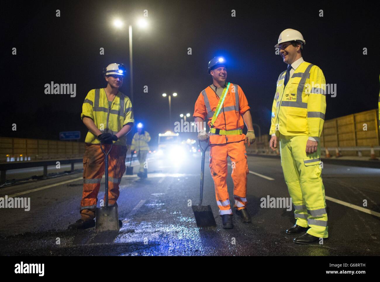 Il Cancelliere dello scacchiere George Osborne incontra i lavoratori su un tratto dell'autostrada M6 vicino a Birmingham, dove ha visto la costruzione di un sistema di gestione stradale mentre la strada era chiusa. Foto Stock