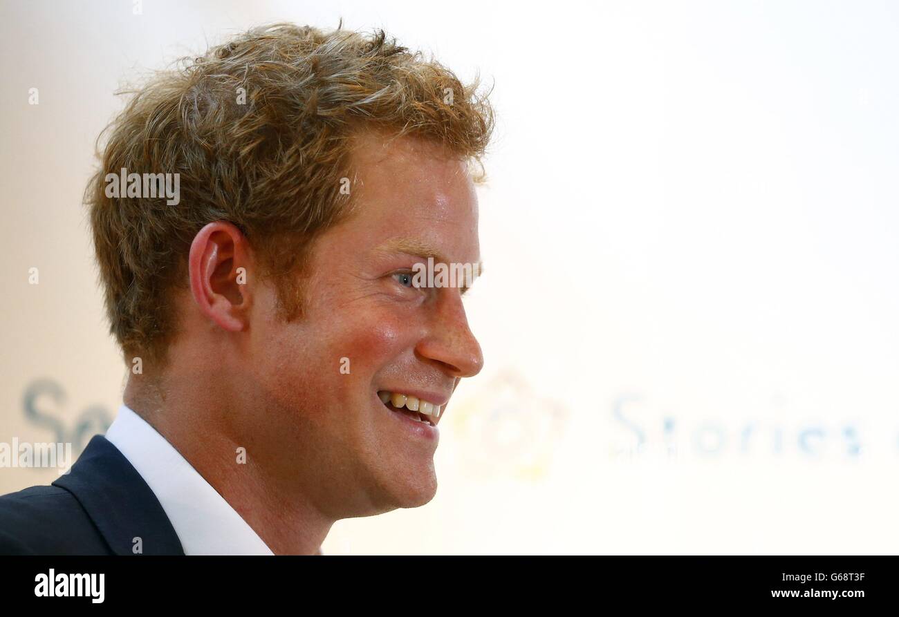 Il principe Harry fa una battuta sulla temperatura calda durante un discorso alla vista privata della mostra fotografica 'Sentebale - Stories of Hope' nel centro di Londra. PREMERE ASSOCIAZIONE foto. Data immagine: Giovedì 25 luglio 2013. Il principe Harry dichiarò stasera di essere pronto a suonare lo zio orgoglioso e protettivo per il suo nuovo nipote Prince George e di "assicurarsi che abbia divertimento". Harry non poteva smettere di infondere il fascio, mentre parlava del nuovo membro della sua famiglia durante la sua visita ad una mostra fotografica a Londra che documentava il lavoro della sua associazione di beneficenza con sede in Africa Sentebale. Ha chiesto quale fosse la sua missione Foto Stock