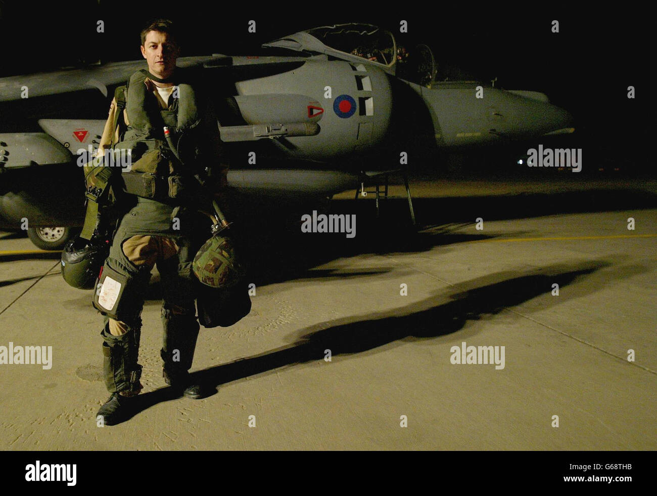 Il pilota britannico della Royal Air Force Flt Lt Ian Townsend è in piedi dal suo Harrier GR7 momenti dopo essere uscito dal suo aereo con i suoi piloni bomba vuoti dopo la sua missione sopra l'Iraq. * Townsend ha fatto cadere due bombe laser Paveway e due bombe freefall distruggendo due veicoli blindati. Foto Stock