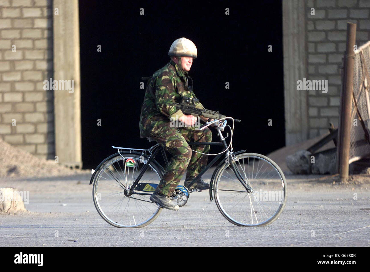 Forze britanniche in Iraq. Un soldato dei Fusiliers, pattuglia la parte meridionale di Basra su una vecchia bicicletta con ruote punzonate. Foto Stock