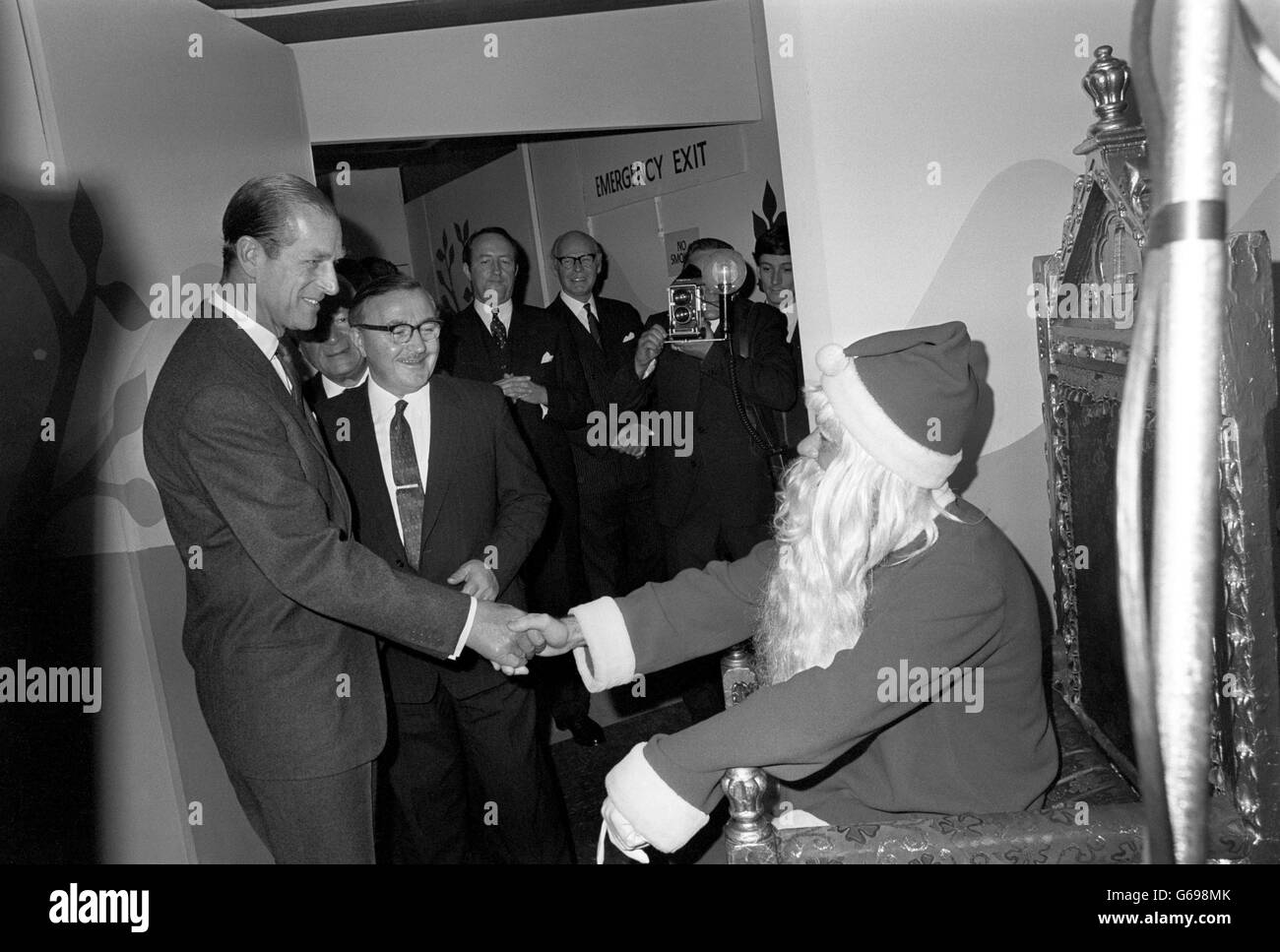 Il principe Filippo, il duca di Edimburgo scuote le mani con Babbo Natale nella grotta di Natale al negozio di Lewis durante la sua visita a Birmingham. Dietro la barba si trova Donald Baker, un 26 anni da Erdington, Birmingham Foto Stock
