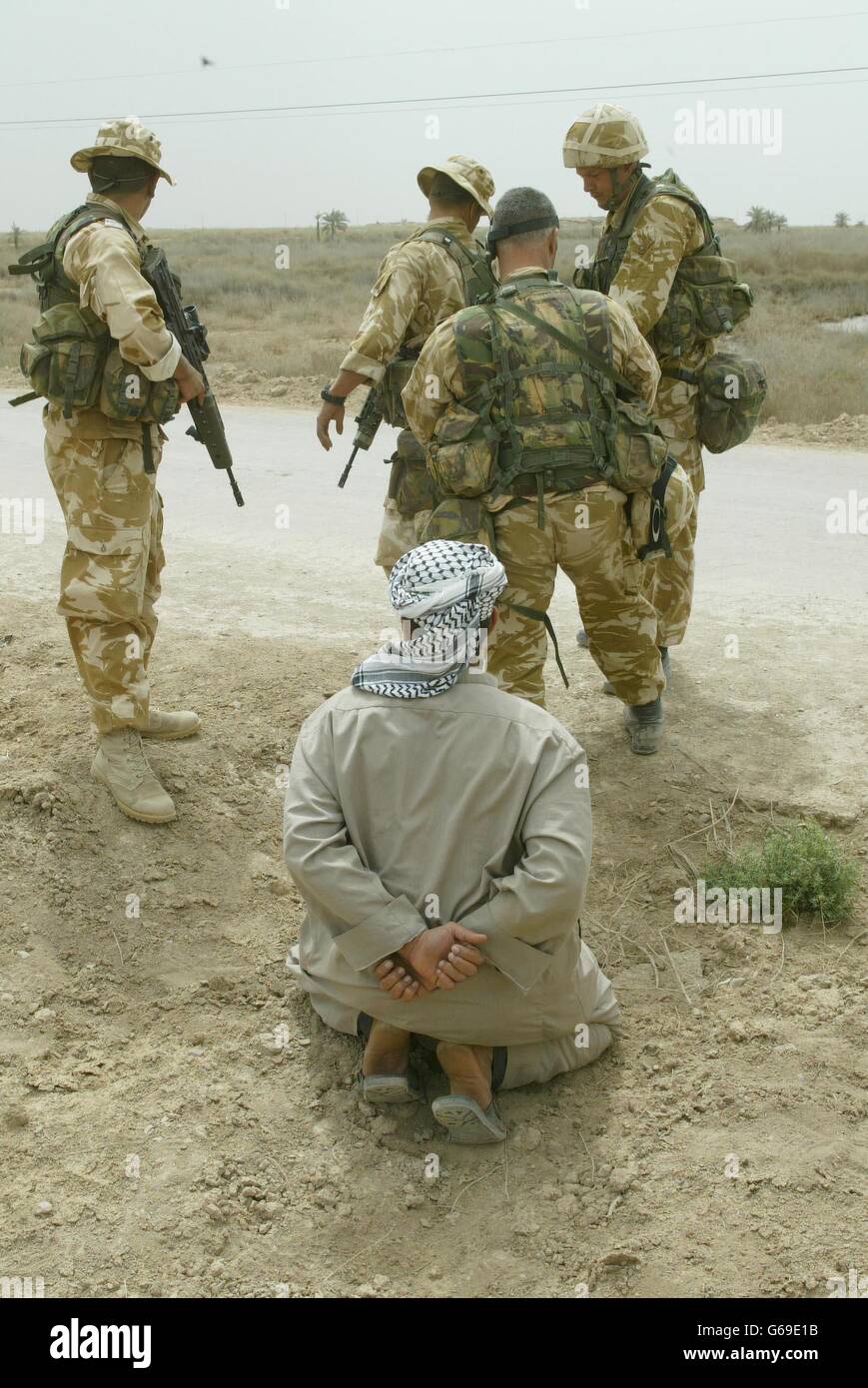 Uomini del 40 Commando Royal Marines prendono un prigioniero, creduto essere esercito iracheno che ha fornito loro le informazioni sulla posizione del quartier generale del partito Ba'ath nella città di al FAW nel sud dell'Iraq. Foto Stock