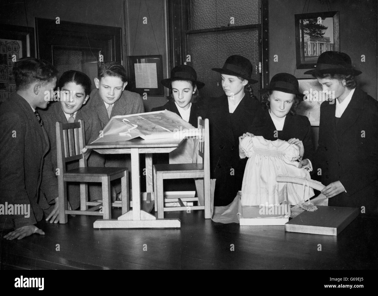 Ragazze e ragazzi delle scuole di Purley (Warehousemen, Clerks e Draper' Schools, Purley e Addington, Surrey), di cui il re H.M. è un patrono, ammirate la loro propria opera - una schiuma di seta blu per bambini, un panno da tavola per vivai e mobili per vivai - a Londra prima di visitare Buckingham Palace. (Da l-r) Norman McDougall, Roger Fletcher, Malcolm Green, Anne Evans, Heather Morgan, Cynthia Jones e Jean May. *scansione a bassa risoluzione - scansione ad alta risoluzione su richiesta Foto Stock