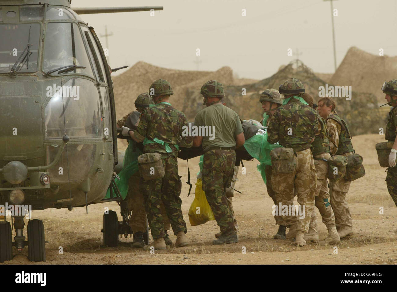 Un soldato britannico innesti il suo casco mentre viene evacuato medico di una base operativa in avanti nel sud dell'Iraq da 33 Squadron Pumas, fuori ad un ospedale di campo per affrontare una ferita alla sua gamba. Foto Stock