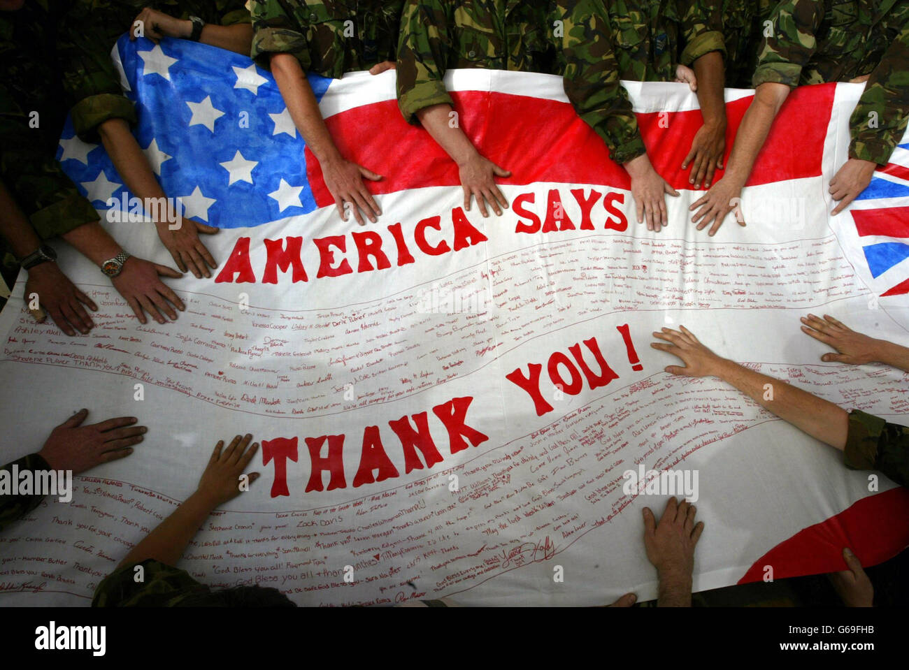 L'equipaggio di terra della British Royal Air Force Harrier GR7 tiene un banner sulla loro base in Kuwait. La bandiera è stata inviata dalla Kingman Academy Middle School degli Stati Uniti dall'Arizona, che si trovano accanto alla base Marina AV-8B Harrier negli Stati in apprezzamento per il lavoro svolto dagli Harriers sull'Iraq. Foto Stock
