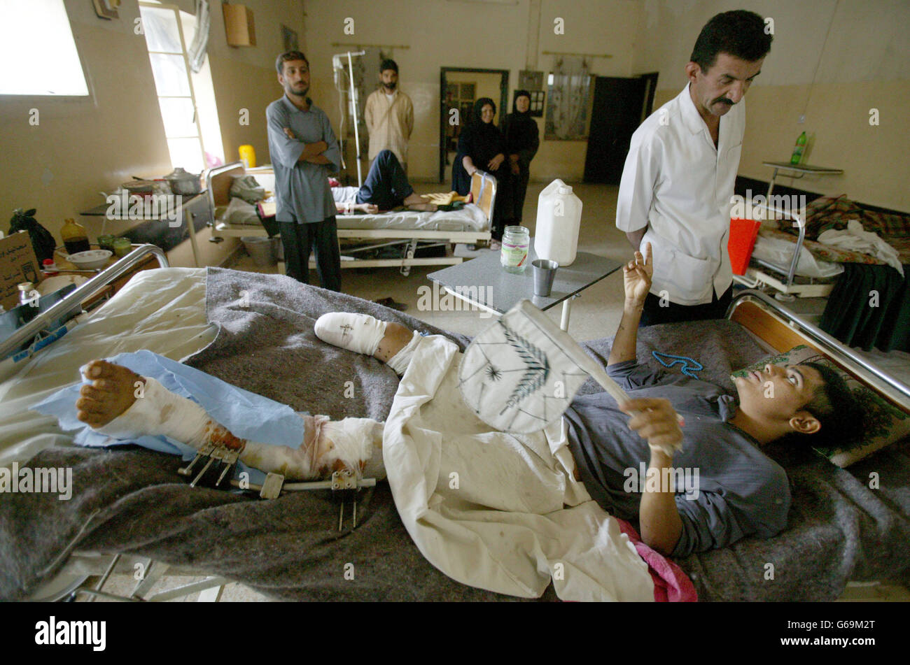 Condizioni meno ideali, dato che un giovane si trova in un letto dell'ospedale generale di Basra, i funzionari affermano di essere vittima di bombardamenti di coalizione. L'Hosptial non ha acqua dolce o elettricità. Foto di PA: Dan Chung / Guardian / mod Pool Foto Stock