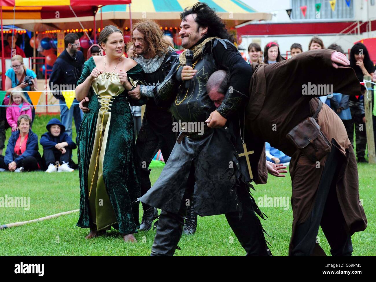 Maid Marion (Jess Cresswell) è preso dagli uomini dello sceriffo durante il 29° festival annuale di Robin Hood alla riserva naturale nazionale della foresta di Sherwood, Edwinstowe, Nottinghamshire. Foto Stock
