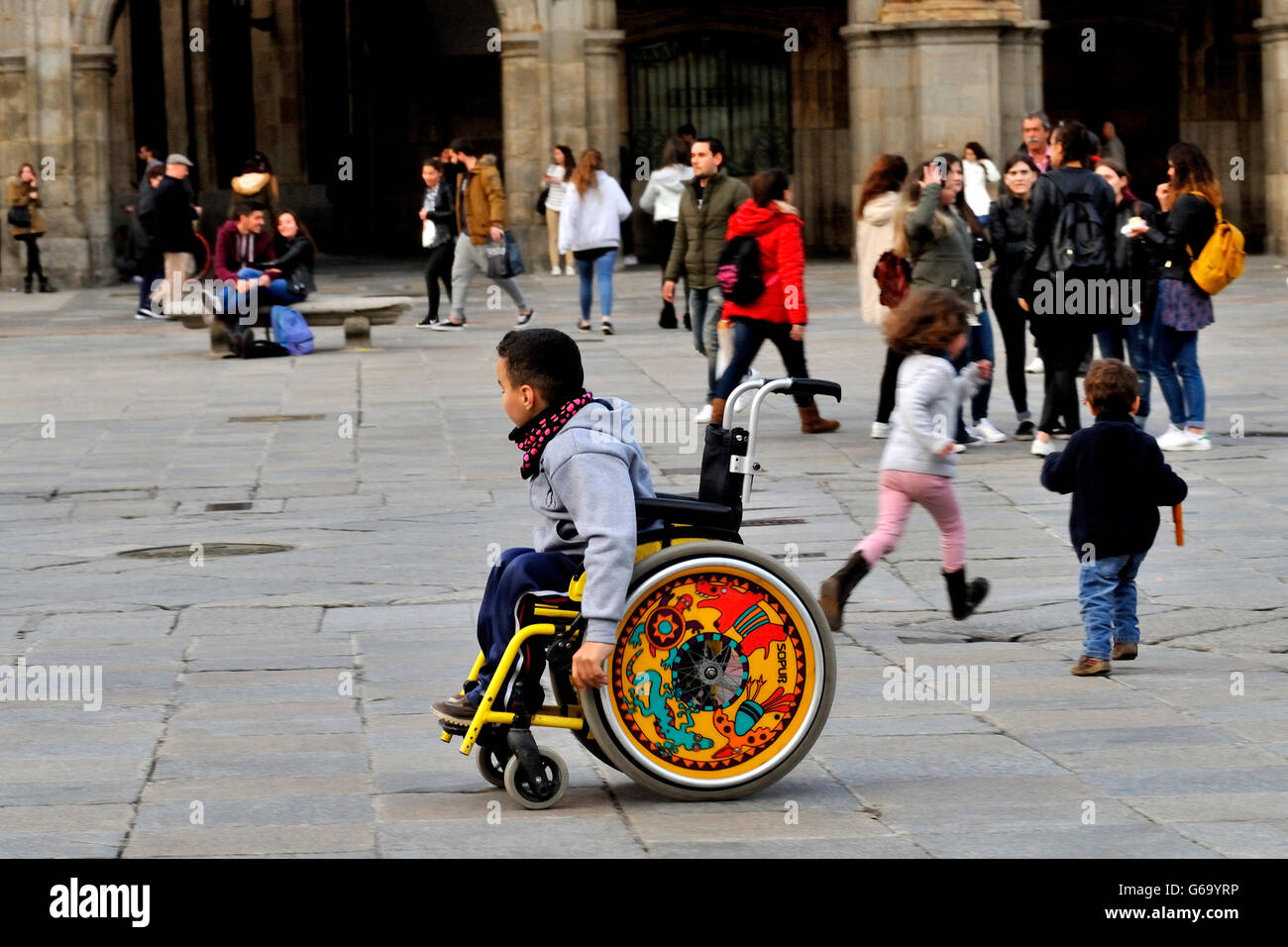 Bambino in sedia a rotelle in Plaza Mayor di Salamanca, Spagna. Foto Stock