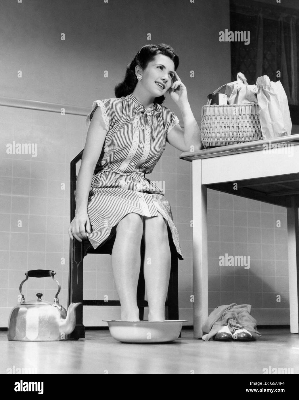 1940s house moglie donna HOME dal supermercato OFF scarpe piedi doloranti SOAKING PENTOLA DI ACQUA CALDA Foto Stock