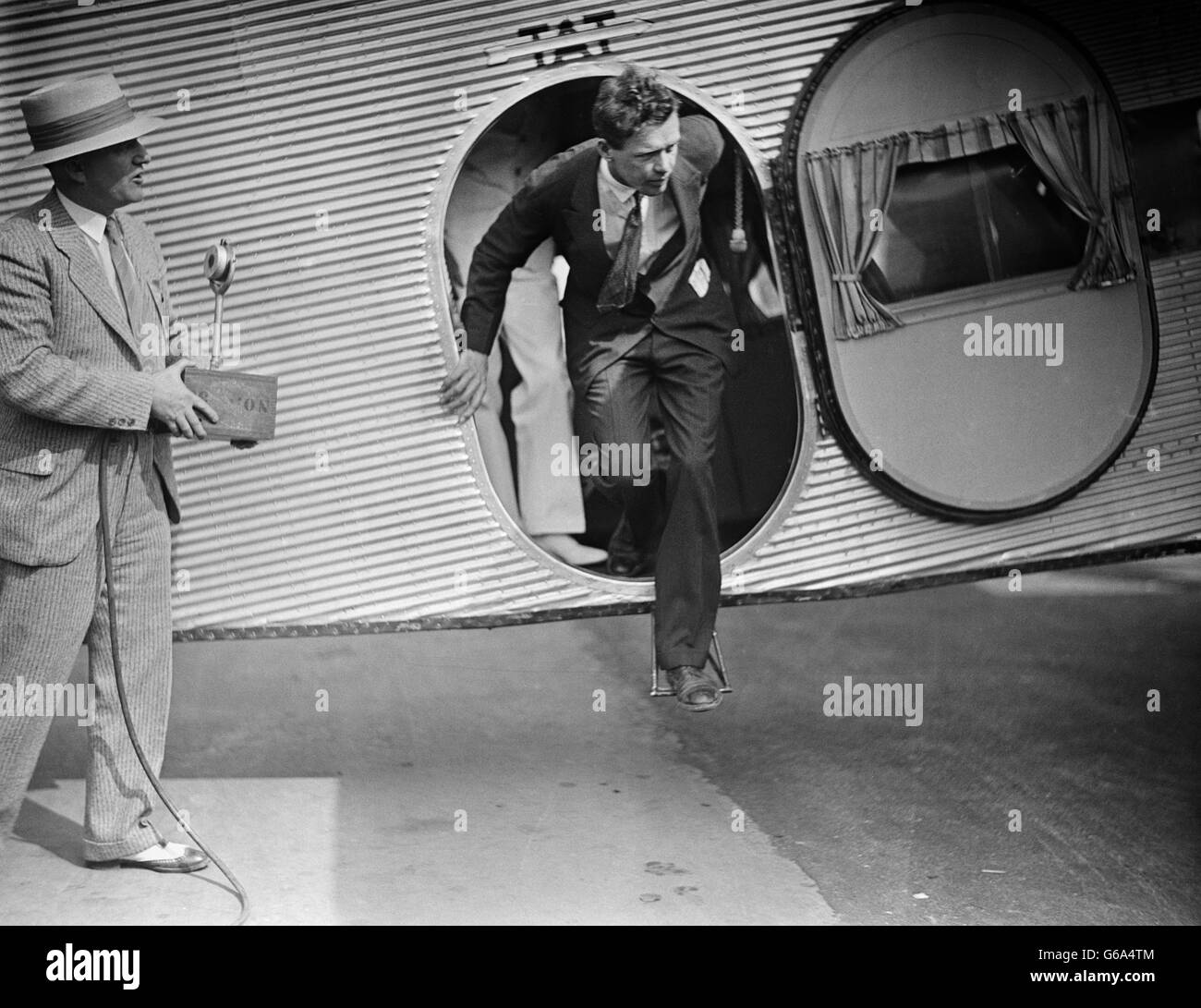 1920s aviatore Charles Lindbergh USCENDO DI TAT FORD TRIMOTOR AEREO REPORTER UOMO IN ATTESA CON MICROFONO Foto Stock