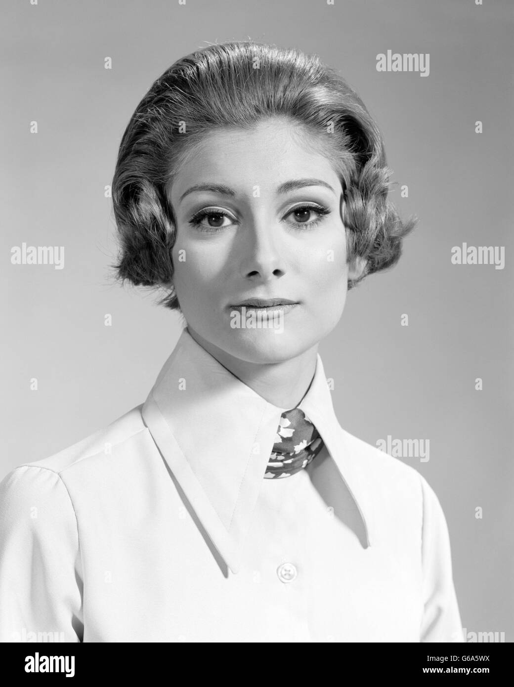Anni sessanta anni settanta ritratto grave donna che guarda la fotocamera camicetta da indossare con grande collare e sciarpa Foto Stock