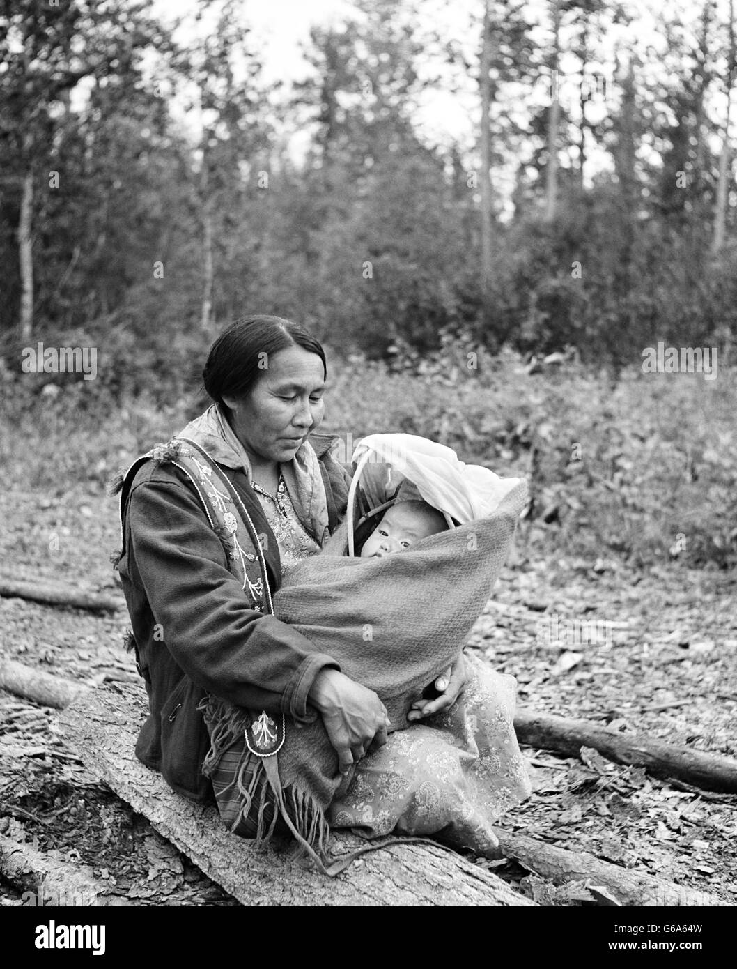 Anni Settanta Native American donna madre HOLDING BABY IN PAPOOSE Israele lo sbarco del fiume di Yukon DAWSON CANADA Foto Stock
