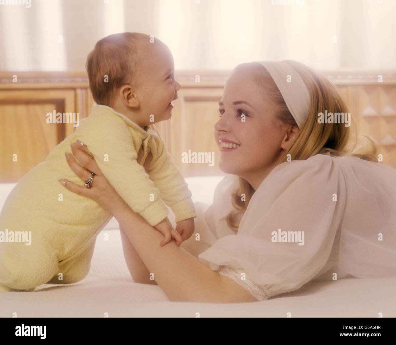 Anni Settanta donna madre IN BIANCO AZIENDA BABY IN GIALLO Foto Stock