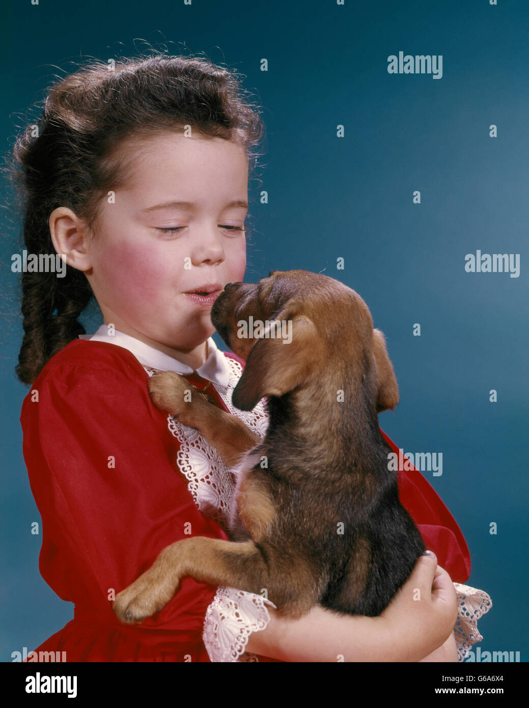 Anni sessanta poco ragazza baciare il suo cucciolo di Beagle Foto Stock