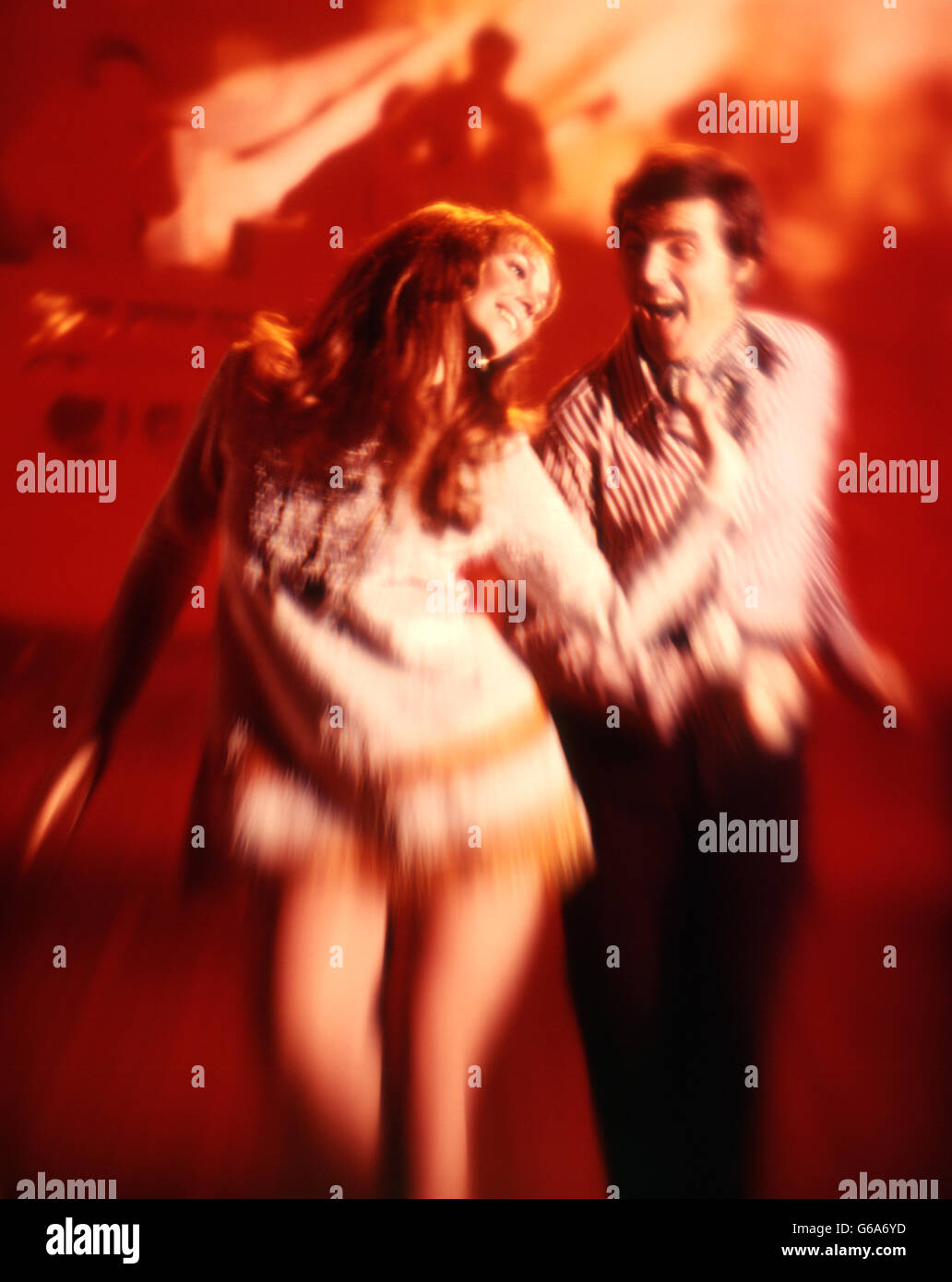 Anni Settanta GIOVANE UOMO DONNA DISCOTECA IN ROSSO le spie lampeggianti Foto Stock