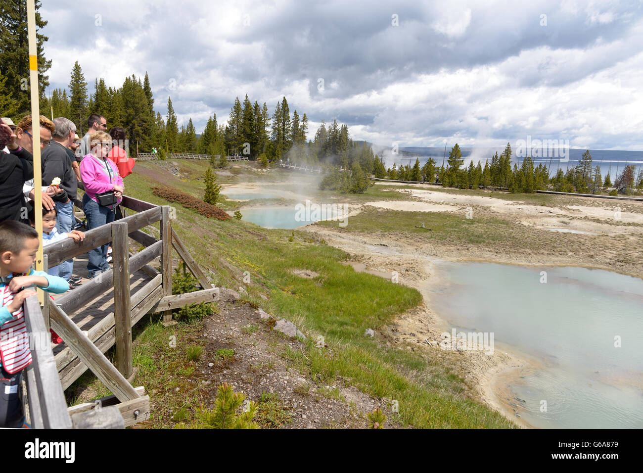 Chiara, aqua primavera calda con profondo foro centrale, il vapore e il litorale calcaree, le persone sul lungomare, West Thumb area di Yellowstone Foto Stock