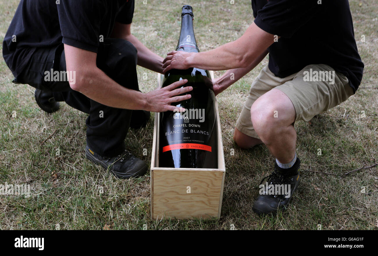 Assistente del Winemaker Josh Donaghay-spire (a sinistra) e del Winemaker Andrew Parley presso la cantina Chapel Down a Tenterden, Kent, ascensore a15 litro bottiglia Nebuchadnetsar, La più grande bottiglia di vino frizzante inglese mai prodotta prima di una foto scattata mentre è pronta a entrare in mostra al Turner Contemporary di Margate da domani come parte della mostra estiva della galleria Curiosità: Arte e piacere di sapere. Foto Stock