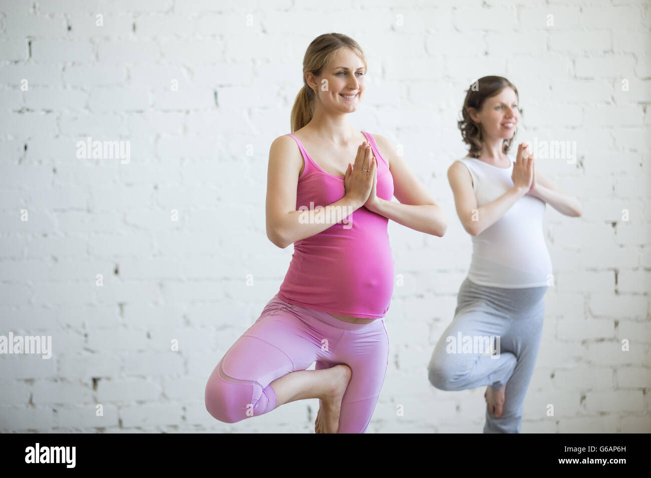 Gravidanza Yoga e fitness concetto. Ritratto di giovane e bella incinta modello yoga che lavora fuori indoor. Gravidanza fitness felice Foto Stock