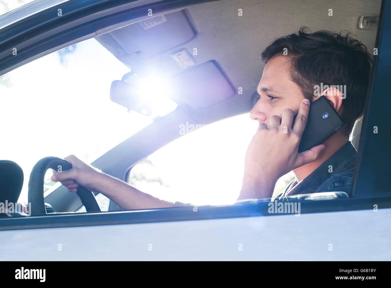 Driver mediante telefono cellulare senza vivavoce durante la guida Foto Stock