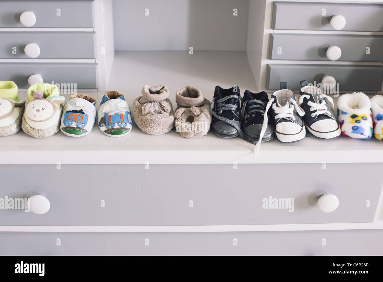 Fila di scarpe per bambini sulla sommità della cassettiera Foto stock -  Alamy