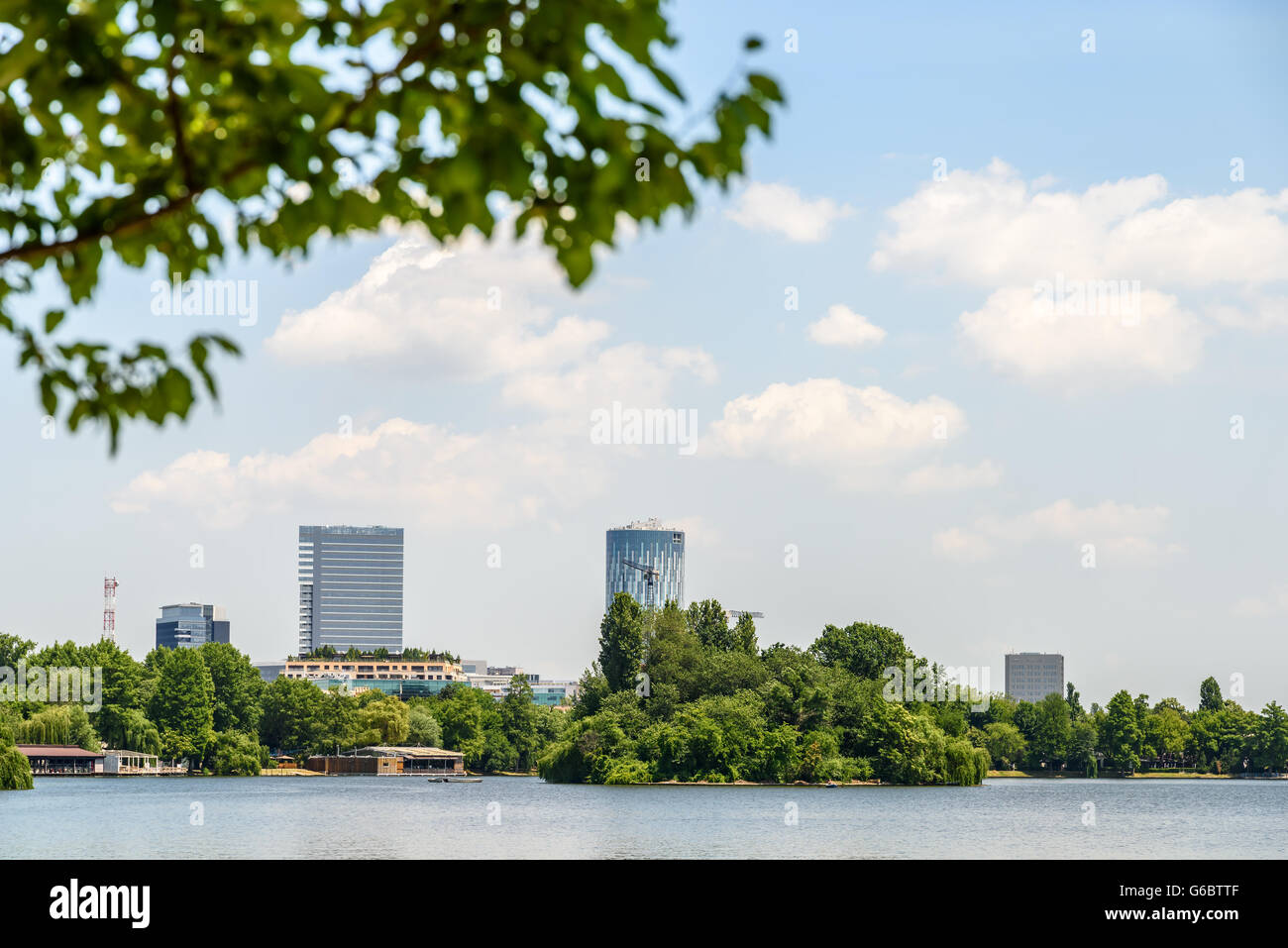 Lo Skyline di Bucarest vista In Herastrau Parco Lago Foto Stock