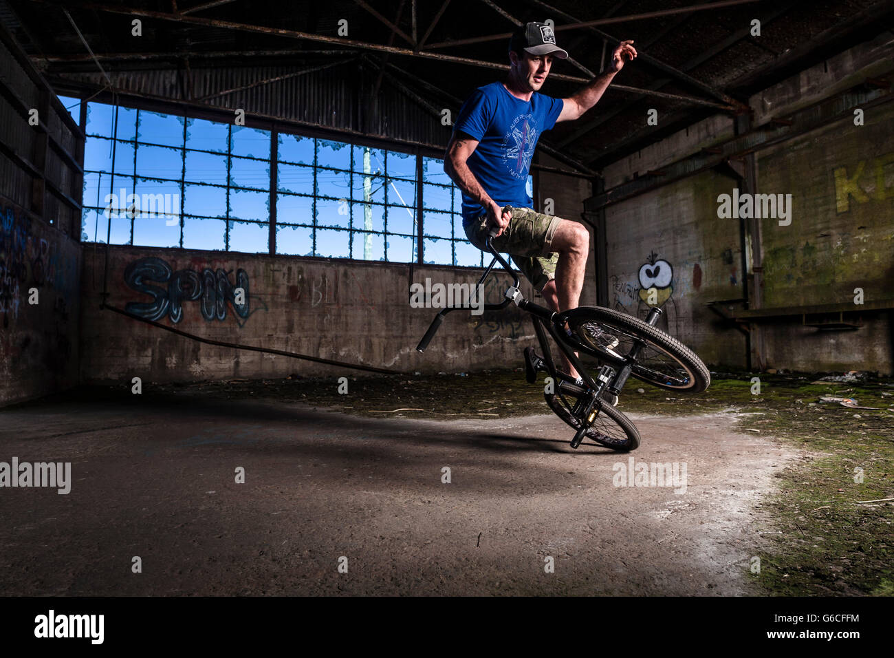 Chris Letchford riding BMX flatland in un vecchio magazzino nella factory di Devonport, la Tasmania. Foto Stock