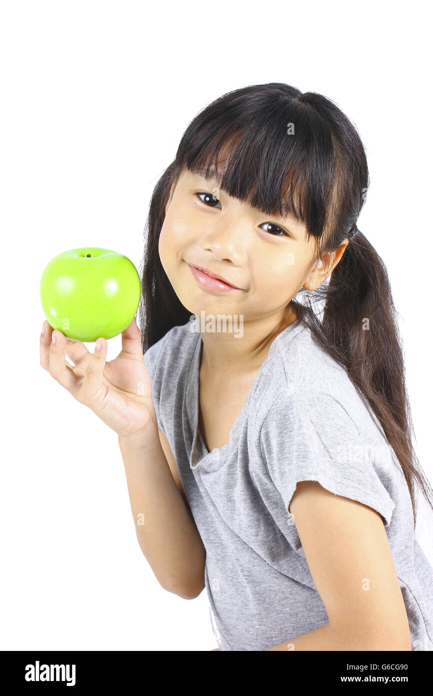 Una bambina si flette il suo muscolo, pur mostrando l'apple Foto Stock