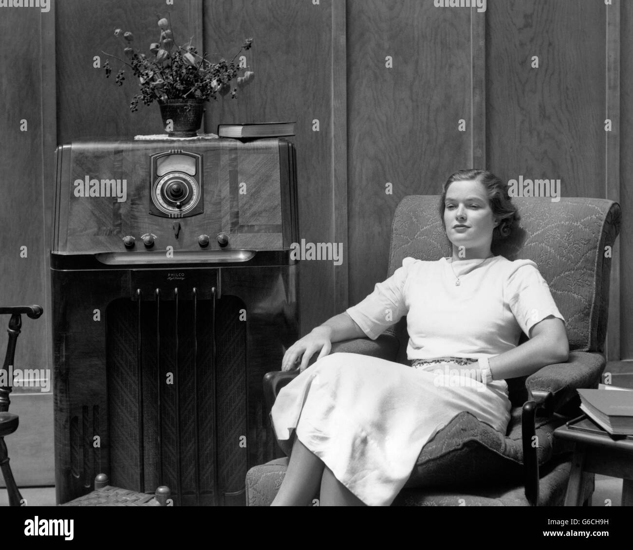 1930s 1940s grave donna seduta nel salotto ascoltando la radio Foto Stock