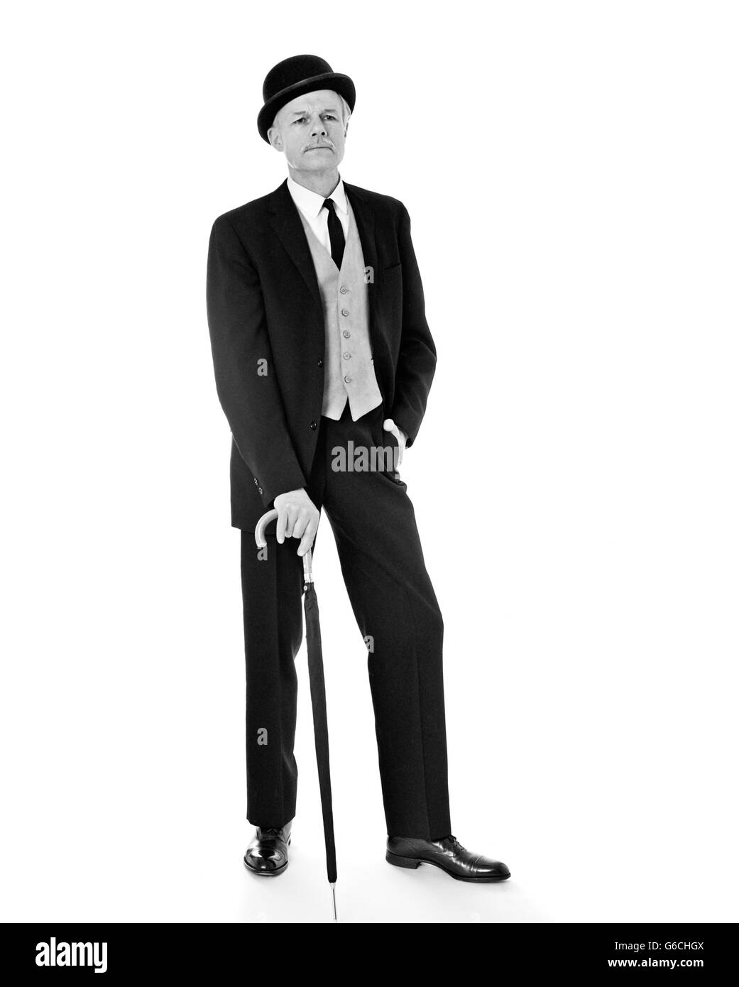 Anni sessanta ritratto a piena lunghezza uomo che indossa IN TRE PEZZI SUIT Bowler cappello con ombrello molto British English Cerca Foto Stock