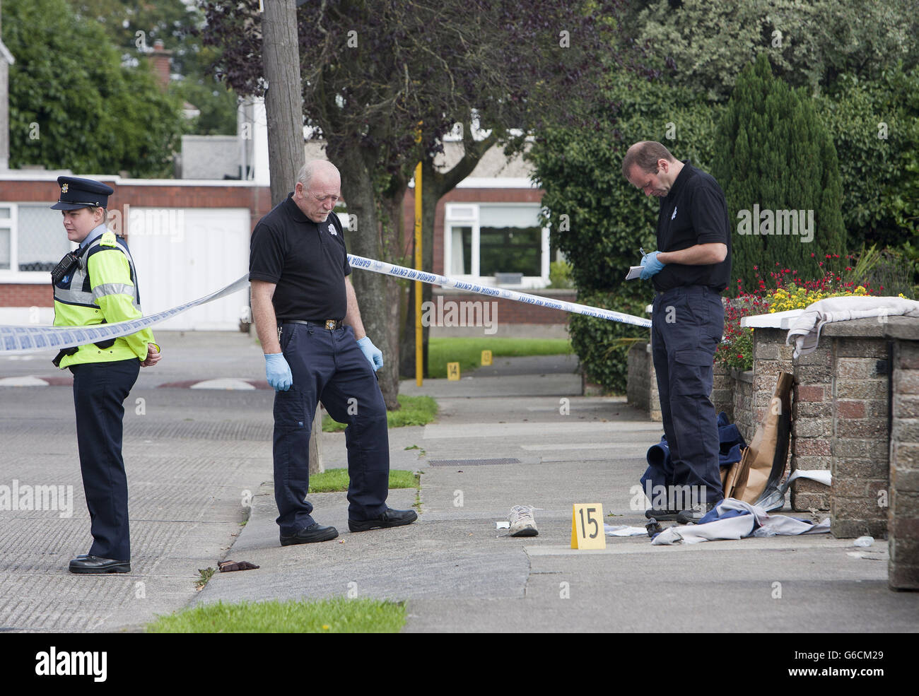 Una squadra forense del Garda all'interno del cordone di Hillcrest Park nella zona di Glasnevin a Dublino Nord, dove un uomo a metà degli anni 30 è stato assistito da paramedici dopo essere stato girato. Data foto: Lunedì 26 agosto, 2013. Vedi la storia della PA POLIZIA Shooting Irlanda. Il credito fotografico deve essere: Liam McBurney/PA Wire Foto Stock